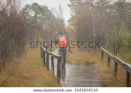 A photographer with a camera in the rain