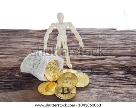 Wooden puppets are collecting Golden bitcoin.On the keyboard put in the sack.And to exchange money.Meaning of doing business Through electronic money