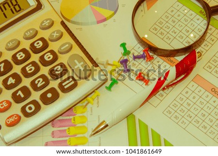 Graphics calculator, magnifier and pen. Analyzing financial data and counting on calculator. Sales earning chart