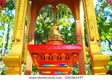 Back of gold Buddha in garden. Background are green contrast with the object that shine yellow. The picture is perfect in living room or Oriental hotel decoration.
