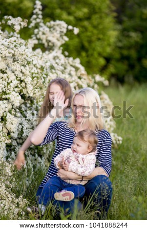 Mother's day. Mom with daughters on a background of green grass