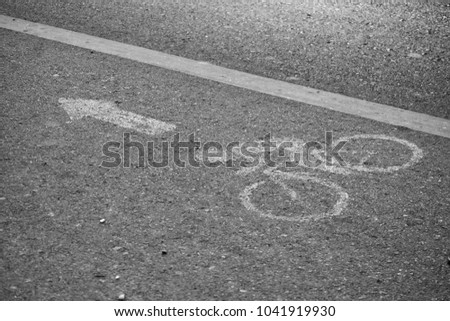 bicycle and arrow paint on road, bike lane sign, black and white tone