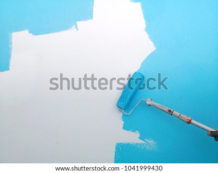 Wall being painted in sky blue paint with paint roller background