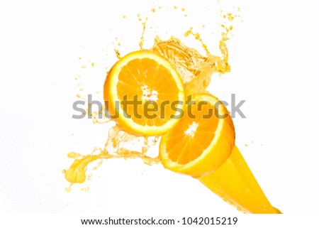 Orange juice splashing on half oranges against a white background