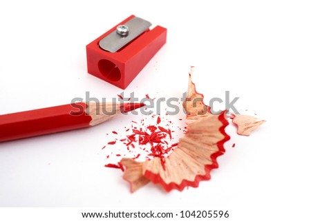 Image of red pencil, shaving and sharpener on white paper