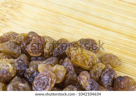 A bunch of raisins from below on a bamboo board close-up