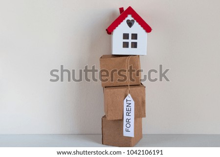 Real estate and mortgage investment. Being an easy way homeowner. house and cardboard boxes on the white background.