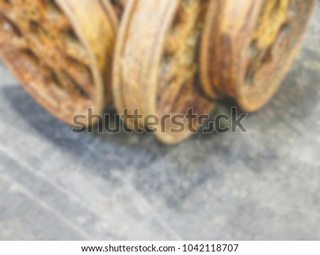 Defocused background of vintage rusty cover wheels on grey background with copy space. Intentionally blurred post production for bokeh effect.