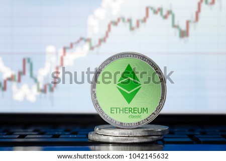 ETHEREUM classic (ETC) cryptocurrency; physical concept ethereum classic coin on the background of the chart Royalty-Free Stock Photo #1042145632