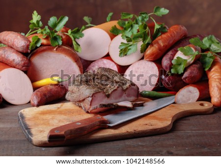 Different sausages and smoked meats on a old wooden table .
