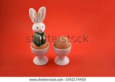 Easter bunny and egg stock images. Easter bunny and egg on a red background. Easter bunny in an egg. Spring decoration images. Easter concept