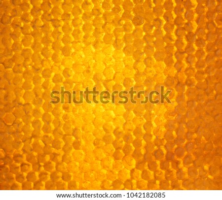 bright Golden background of bee honeycombs filled with sweet sticky honey