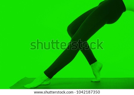 Young girl doing a yoga pose in green color