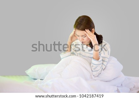 Asian woman sitting on bed having a headache from depression.Isoleted Dicut Clipping Path Image.