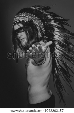 american native Indian men in a headdress of feathers black and white photo