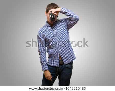 Man Looking Through A Vintage Camera against a grey background