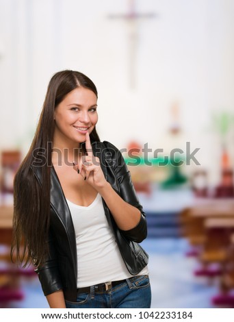 Pretty Woman Making A Keep It Quiet Gesture in a church