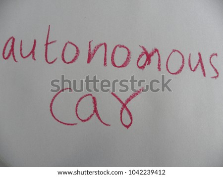 Text autonomous car hand written by crimson oil pastel on white color paper