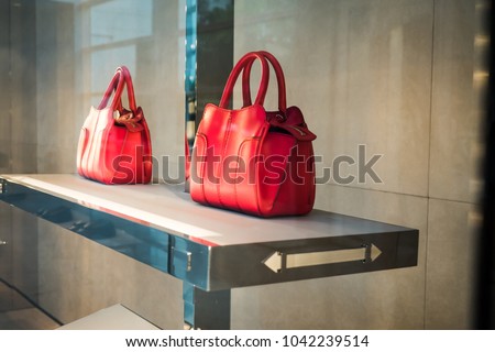 Premium luxury Fashion brand name purse on shelf at shopping mall.