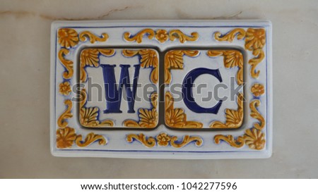 WC, portuguese or spanish ceramic tiles with signs for toilets or restrooms