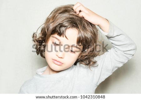 little girl scratching her head