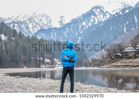 a traveller expressing freedom on his holiday in a peaceful calm location among mountains