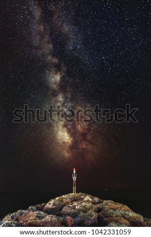 Milky Way galaxy over the rocky seacoast. Milky Way galaxy over the rocky seacoast with lighting antenna. The night sky is astronomically accurate.