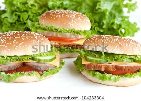 three hamburger with meat and vegetables