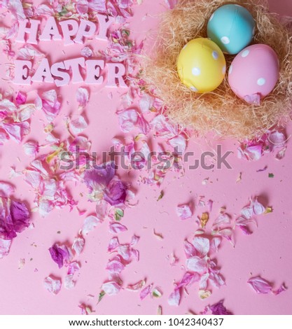 Colorful Easter Eggs in a nest with HAPPY EASTER text against pastel pink background