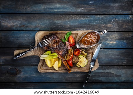 Ribeye steak on bone served with sauce Jack Daniels