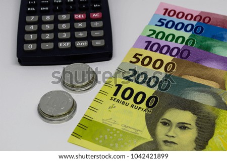 Indonesia Rupiah banknotes with calculator and coins in white background. Financial and Business concept.