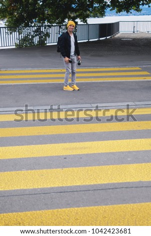 Happy man in yellow pedestrian crossing zebra road.