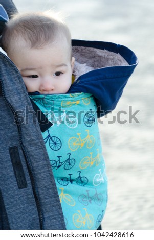 Infant boy in blue baby carrier