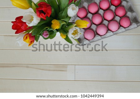 Easter. Pink easter eggs and tulips lie on a wooden background. Flat lay. Bird's Nest. March 8. Pastel shades of pink. Wooden background. Conceptual photo. St. Patrick's Day. Easter pink rabbit.