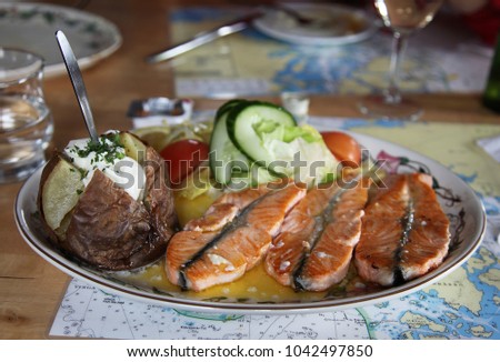 Traditional Icelandic dish with salmon steak and baked potatoes and vegetables Royalty-Free Stock Photo #1042497850