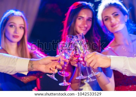 Friends with alcoholic drinks at a party.