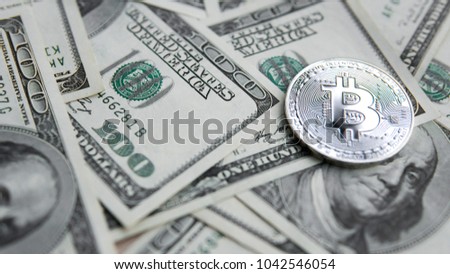 Silver Bitcoins on US dollars. Digital currency close-up. Virtual money. Crypto currency. Metal coins of bitcoins on banknotes of one hundred dollars. Exchange. Bussiness, commercial.