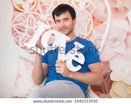 Happy caucasian man holding love word. Love and Valentine's Day concept. 