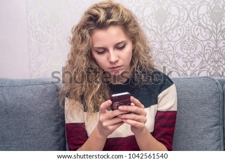 girl plays in the phone, loose hair, texting the guy