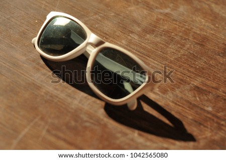 white sunglasses laying on the old wooden table , summer tourism concept , design fashion
