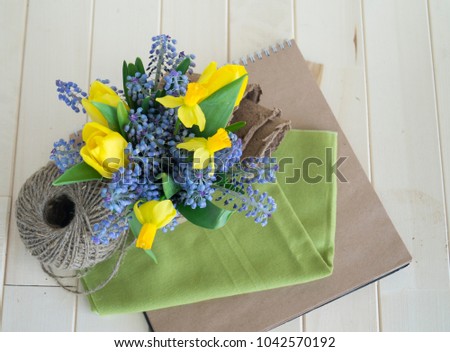 Bouquet of daffodils, tulips and Muscari.Easter. The bird's nest. Wooden background. The style of eco.Green,brown,blue, lilac and yellow.