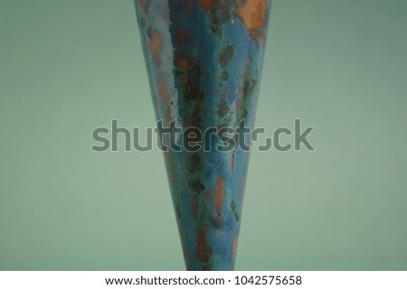 Close-up of ceramic glazed surface on mint green background. Background image.