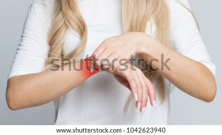 Closeup of female arm holding her painful wrist caused by prolonged work on the computer, laptop/Carpal tunnel syndrome, arthritis, neurological disease concept, 
coloured in red/Numbness of the hand 