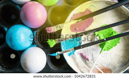Sets of Easter eggs painting in pastel tone colour. Brushes and plate also are in picture.
