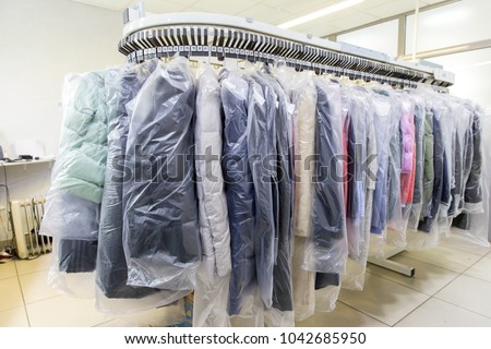 Clothes after dry cleaning in the laundry Royalty-Free Stock Photo #1042685950