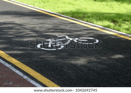 New black asphalt road for cyclists and runners, yellow stripes, markings. Summer sports background 