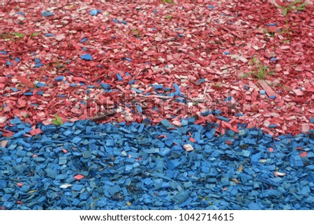Painted decorative wood shavings on a lawn with grass and trees. Colorful summer and autumn background 