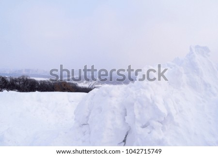 View through the white snow mountain on the big city below
