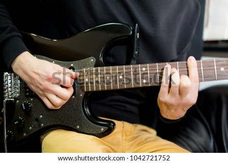 Guy plays guitar close up.