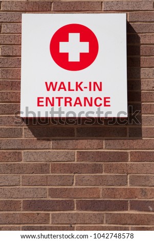 Walk in emergency entrance sign on brick building